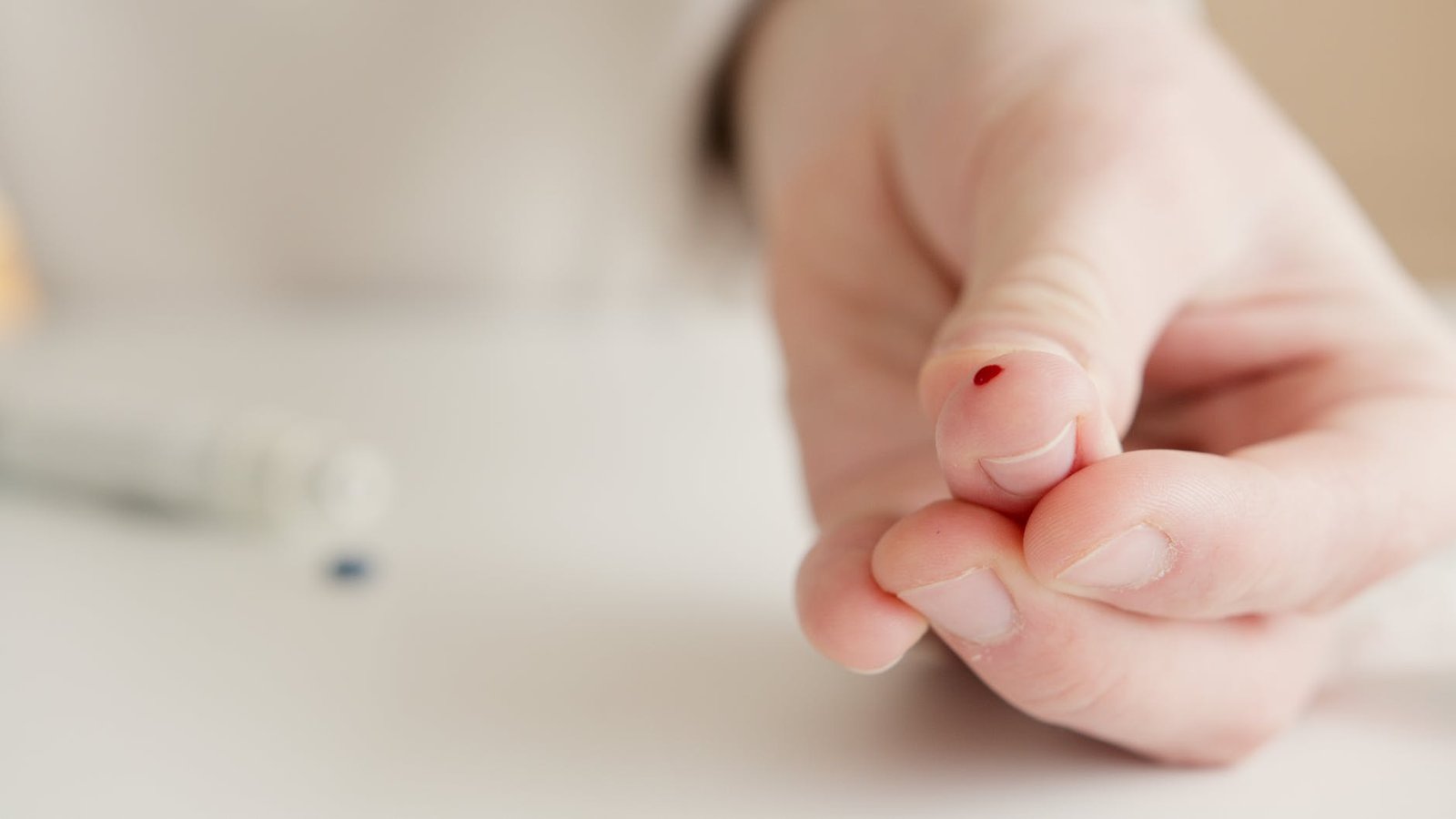 person with tiny blood on finger after a blood test