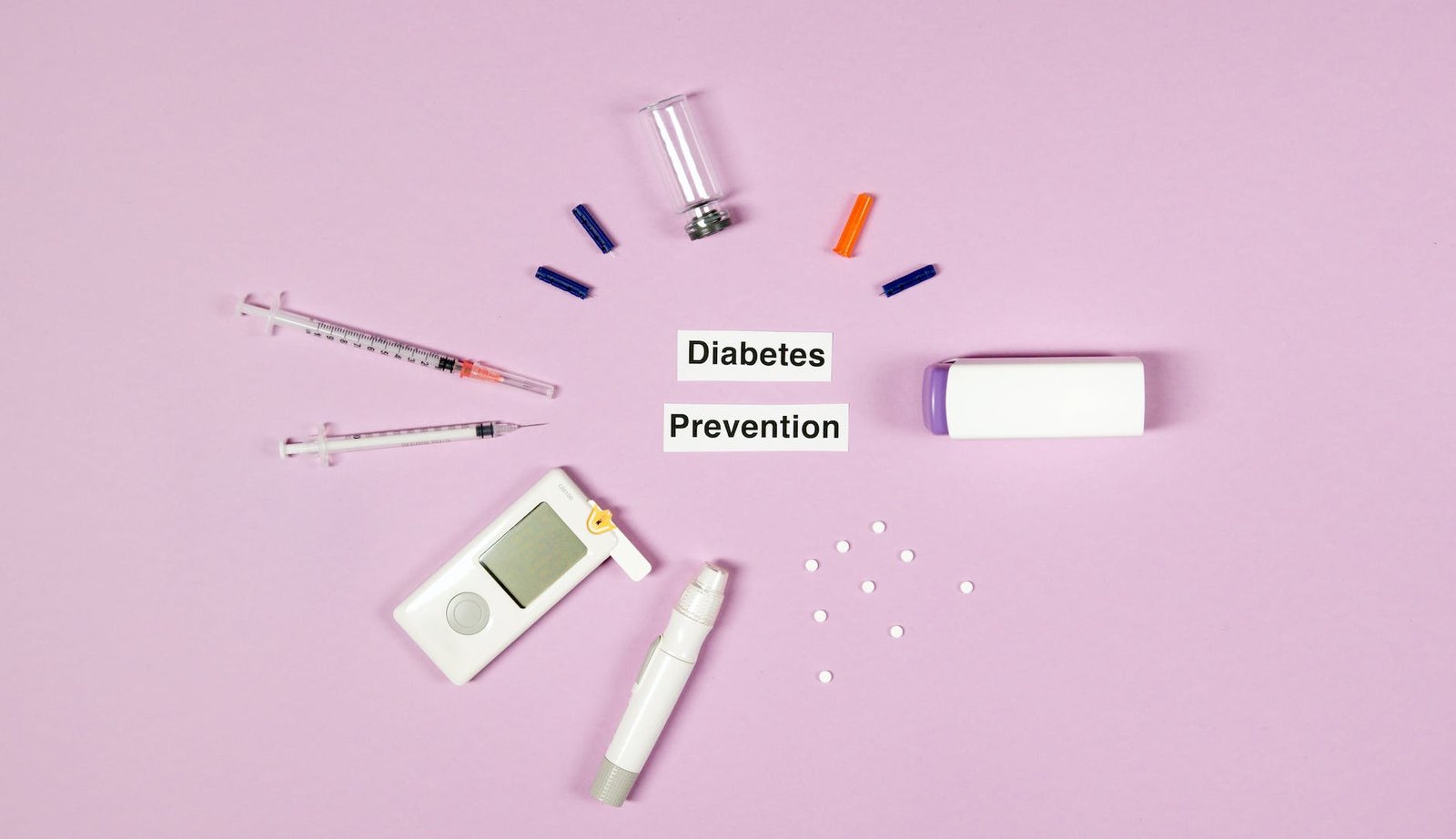 diabetes prevention text on pink background with medical supplies