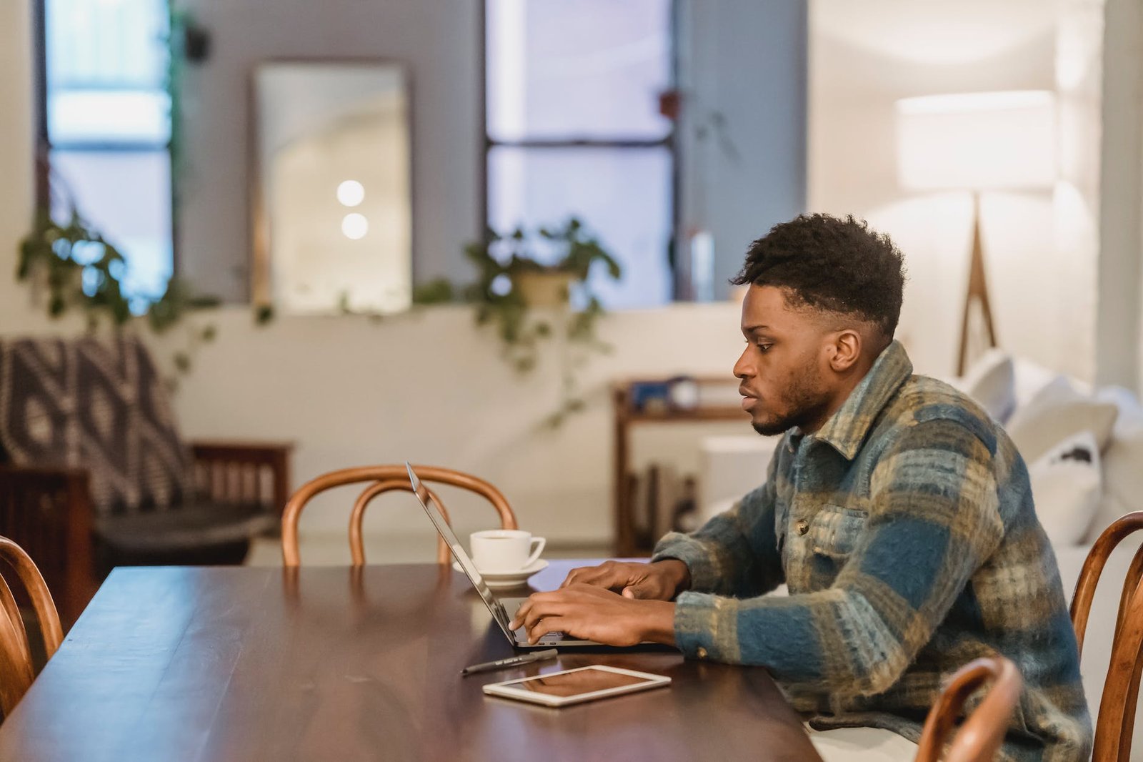 concentrated black man working on laptop at home office