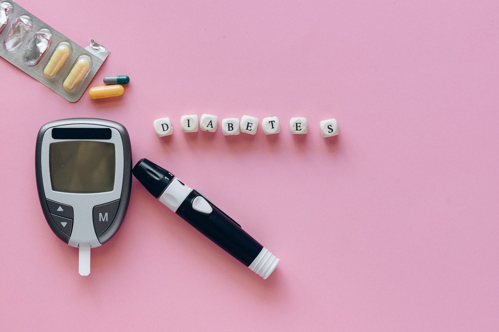 close up shot of a glucometer beside capsules